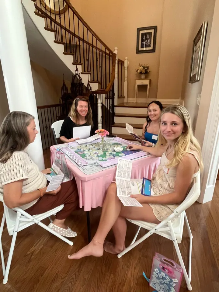 Mahjong party table with guests learning to play